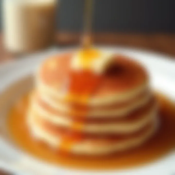 A close-up of fluffy pancakes with a drizzle of maple syrup